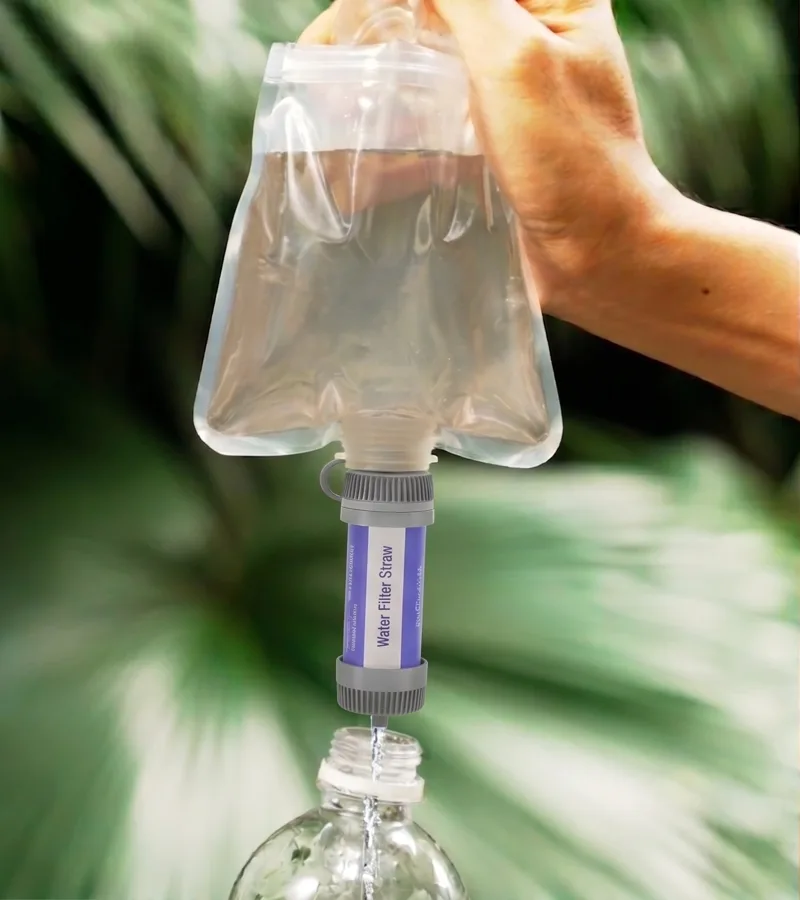 Squeezing water from the Survival Sip pouch through the filter into a bottle